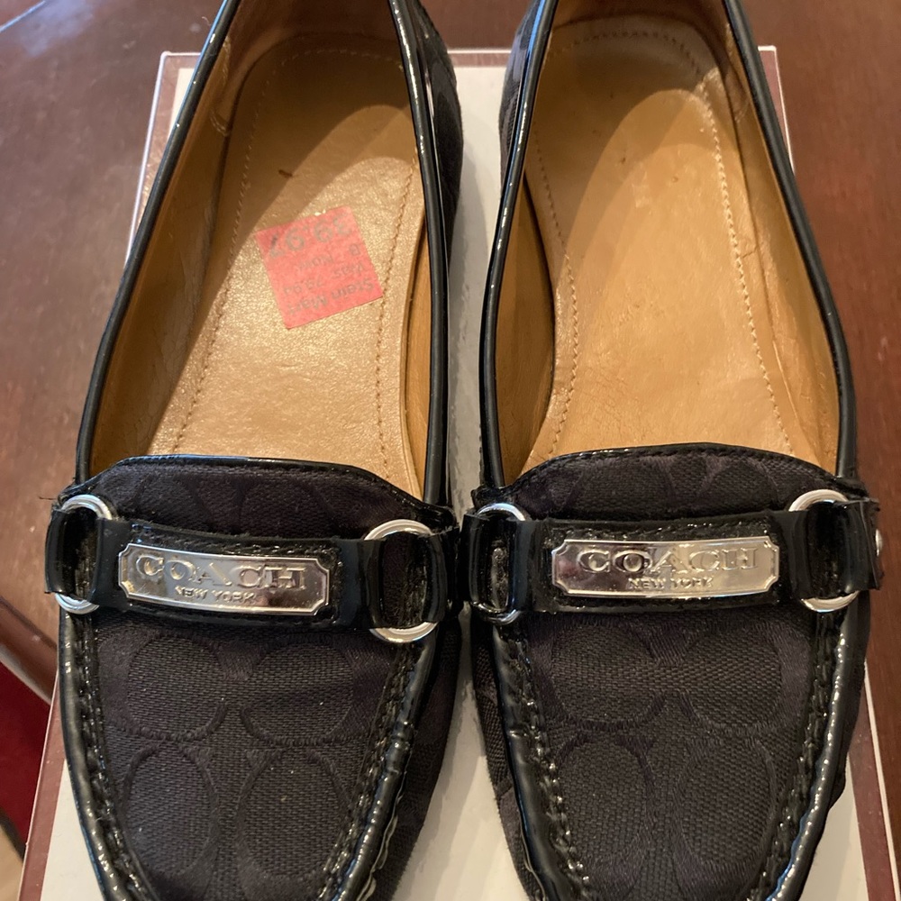 Coach Signature C’s Black with silver hardware loafers.